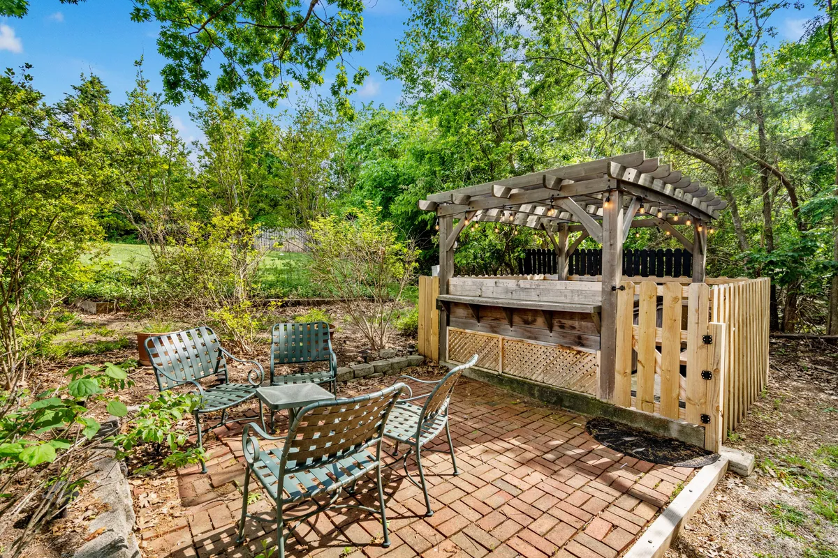 An inviting outdoor bar area and seating are set in a landscaped garden, ideal for social gatherings or relaxing evenings under the stars. The setup encourages guests to take advantage of resort amenities that extend the suite’s enjoyment into the outdoors.